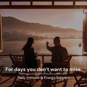 Two people sitting on a wooden deck overlooking a scenic view with text about daily immune and energy support.