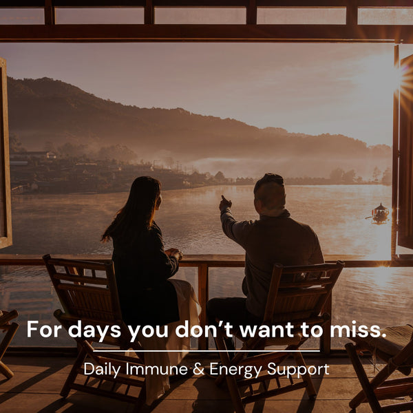 Two people sitting on a wooden deck overlooking a scenic view with text about daily immune and energy support.